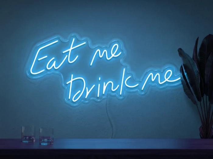 Neonskylt «Eat Me Drink Me» i isblå LED-neon, monterad på vägg