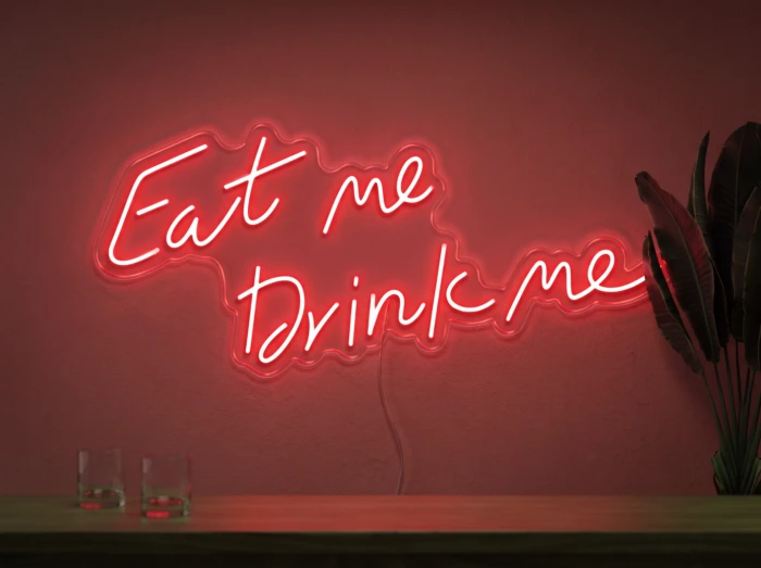 Neonskylt «Eat Me Drink Me» i röd LED-neon, monterad på vägg