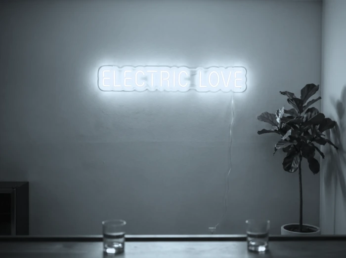 Neonskylt «Electric Love» i iskall vit LED-neon, monterad på vägg
