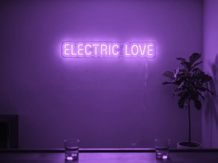 Neonskylt «Electric Love» i lila LED-neon, monterad på vägg