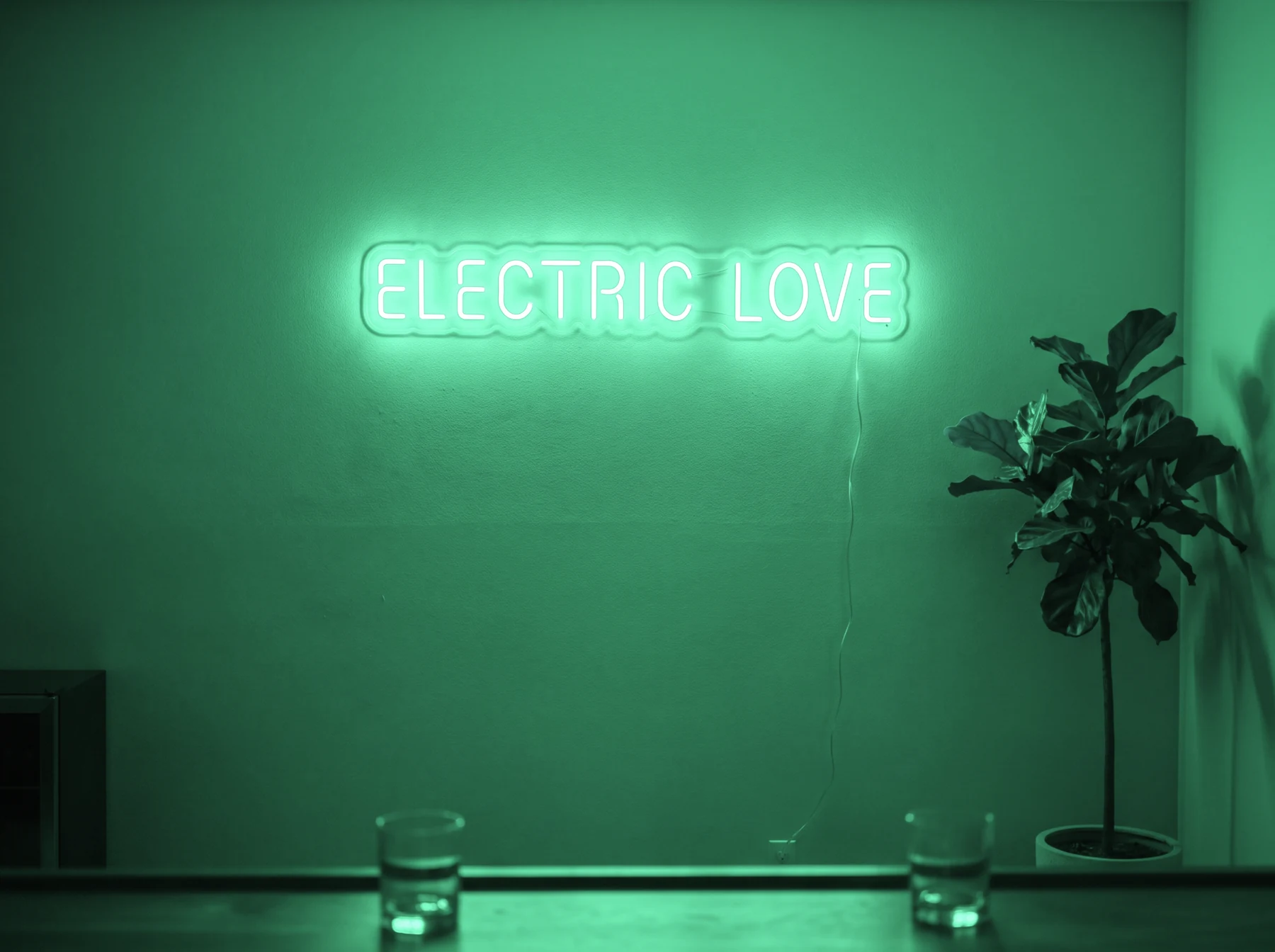 Neonskylt «Electric Love» i mintgrön LED-neon, monterad på vägg