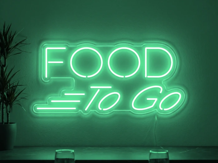 Neonskylt «Food To Go» i mintgrön LED-neon, monterad på vägg