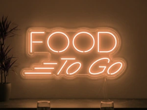Neonskylt «Food To Go» i orange LED-neon, monterad på vägg