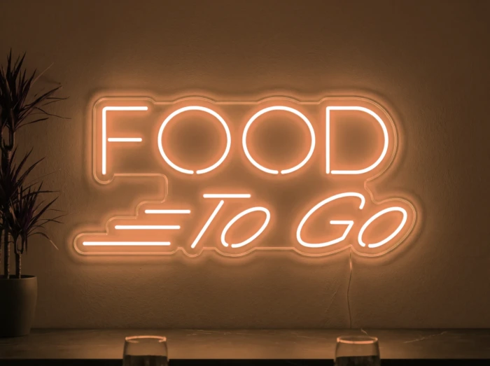 Neonskylt «Food To Go» i orange LED-neon, monterad på vägg