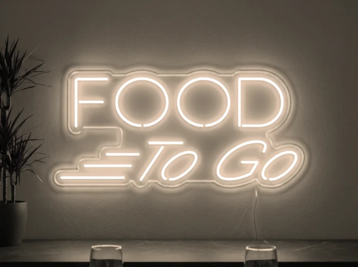 Neonskylt «Food To Go» i varmvit LED-neon, monterad på vägg