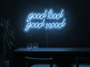 Neonskylt «Good Food Good Mood» i isblå LED-neon, monterad på vägg