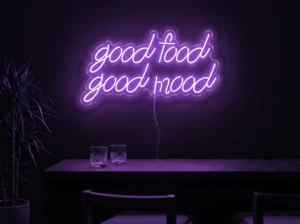 Neonskylt «Good Food Good Mood» i lila LED-neon, monterad på vägg
