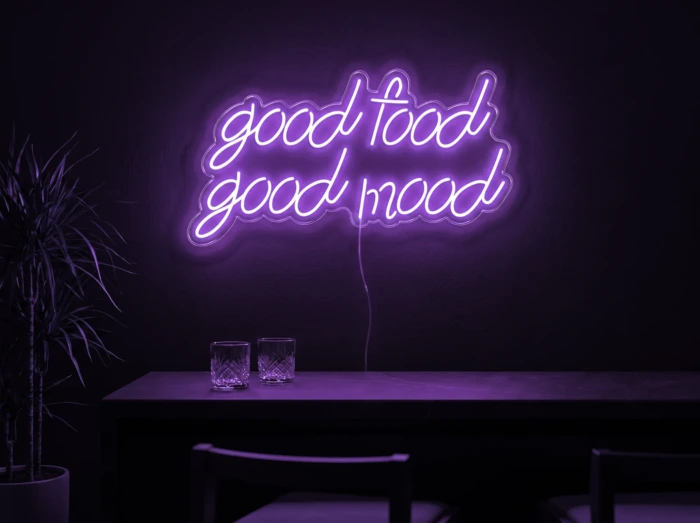 Neonskylt «Good Food Good Mood» i lila LED-neon, monterad på vägg