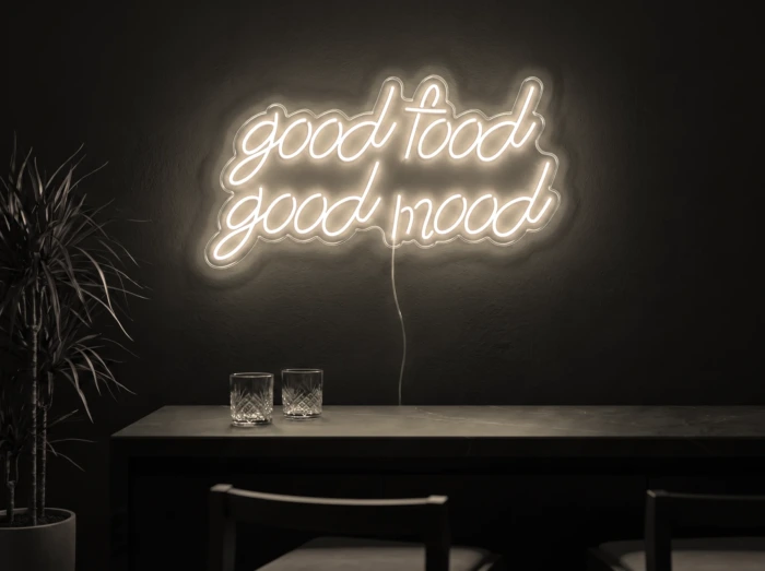 Neonskylt «Good Food Good Mood» i varmvit LED-neon, monterad på vägg