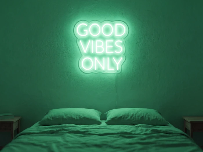 Neonskylt «Good Vibes Only, versaler» i mintgrön LED-neon, monterad på vägg