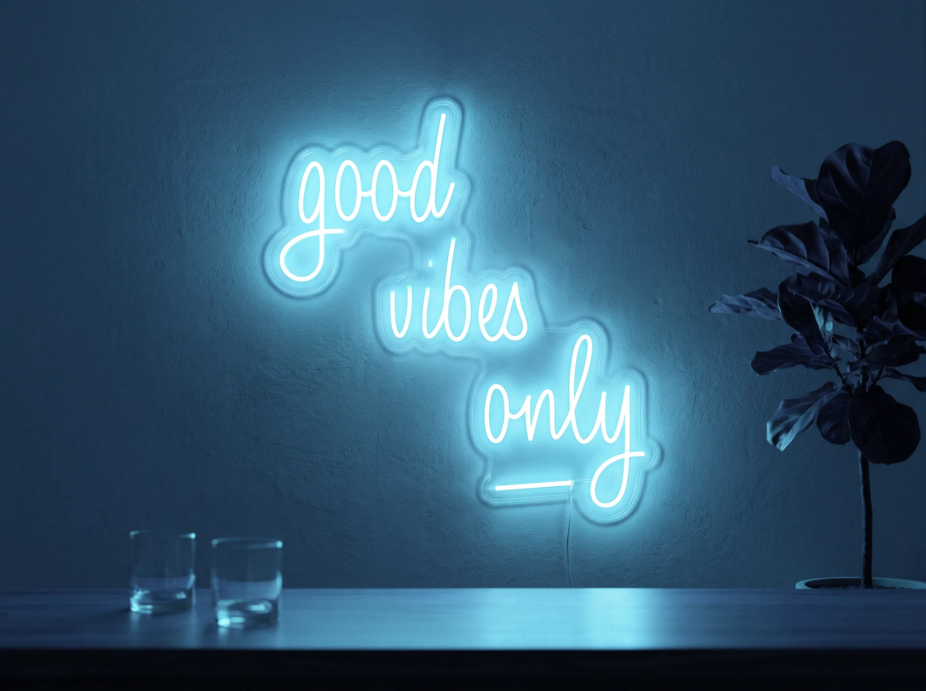 Neonskylt «Good Vibes Only, skrivstil» i isblå LED-neon, monterad på vägg