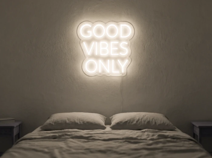 Neonskylt «Good Vibes Only, versaler» i varmvit LED-neon, monterad på vägg