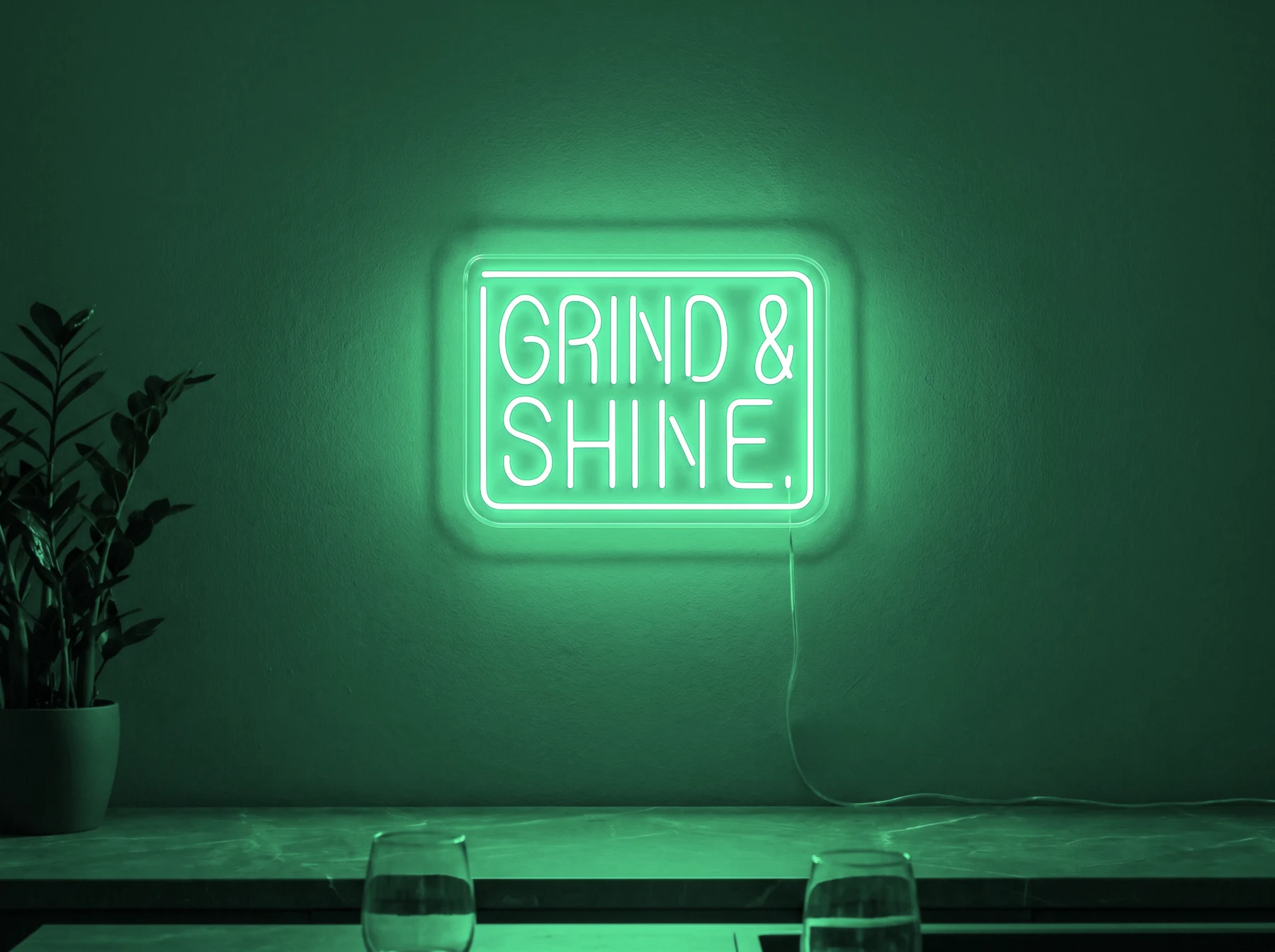 Neonskylt «Grind & Shine» i mintgrön LED-neon, monterad på vägg
