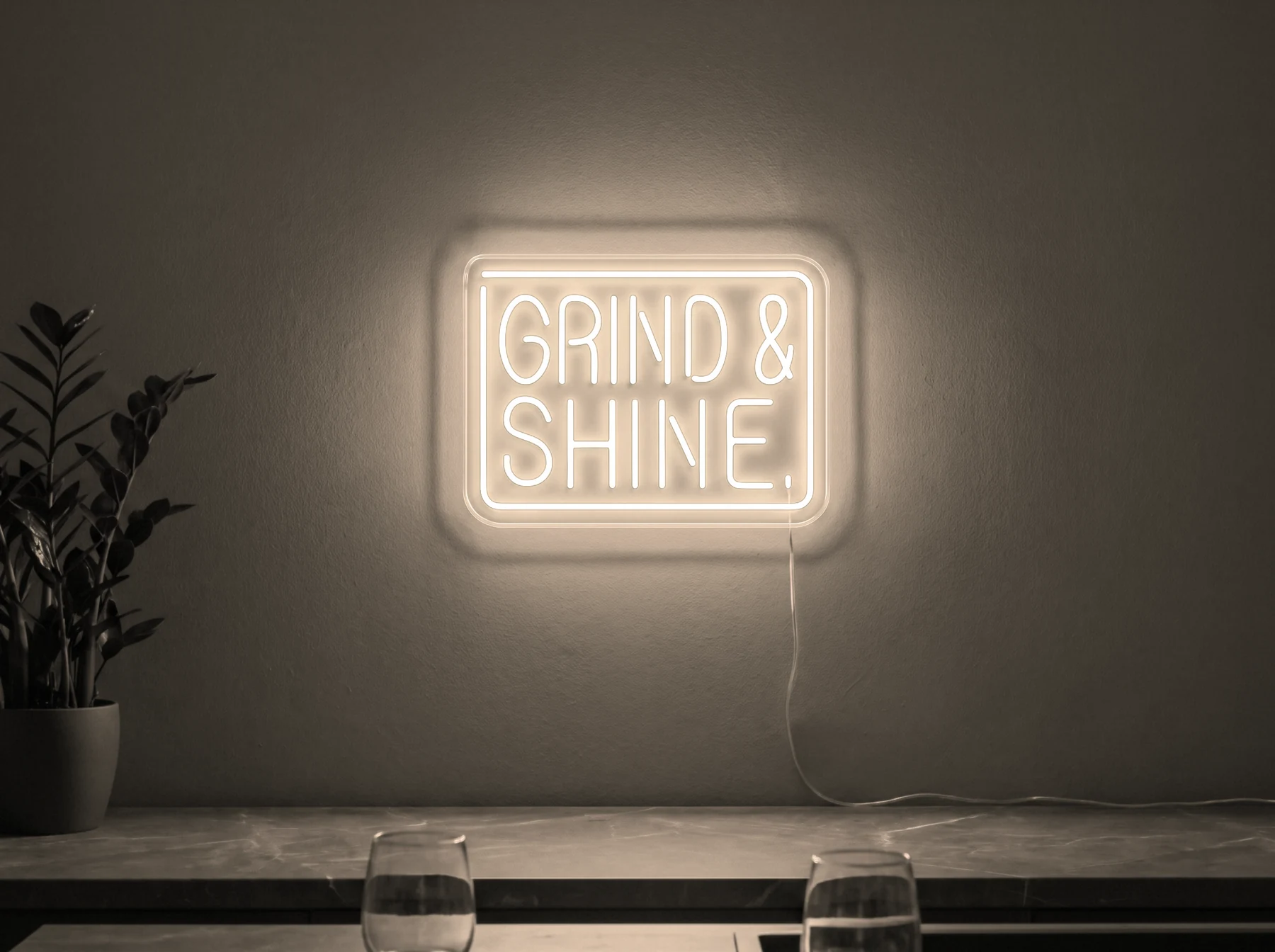 Neonskylt «Grind & Shine» i varmvit LED-neon, monterad på vägg