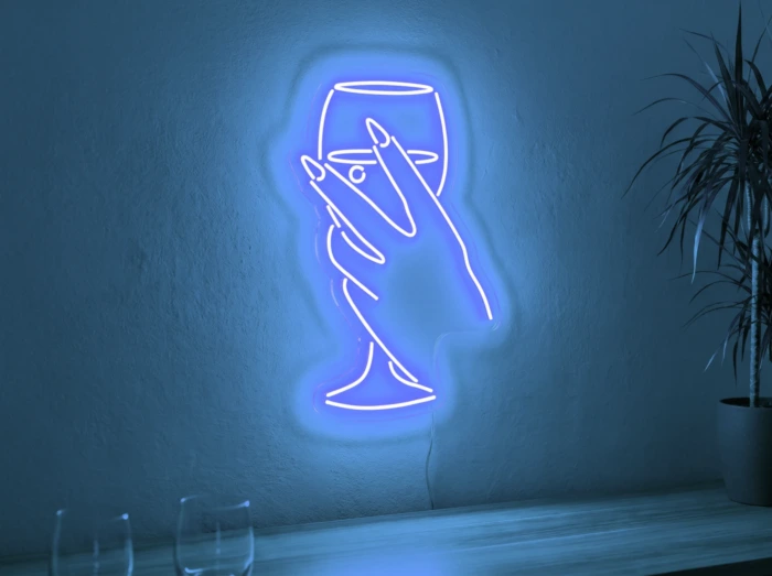 Neonskylt «Hand med glas» i isblå LED-neon, monterad på vägg