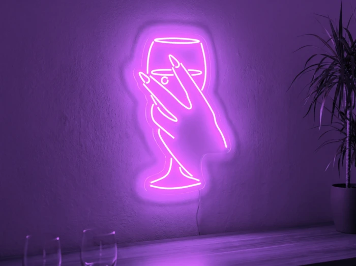 Neonskylt «Hand med glas» i lila LED-neon, monterad på vägg
