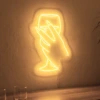Neonskylt «Hand med glas» i orange LED-neon, monterad på vägg
