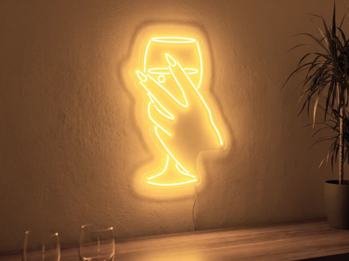Neonskylt «Hand med glas» i orange LED-neon, monterad på vägg