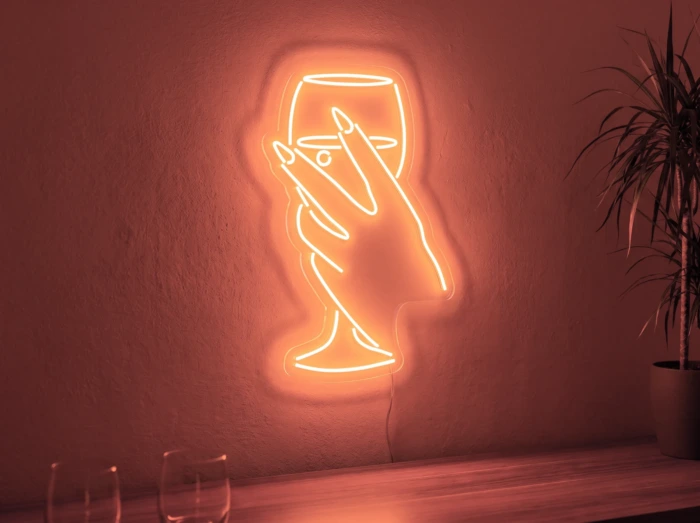 Neonskylt «Hand med glas» i röd LED-neon, monterad på vägg