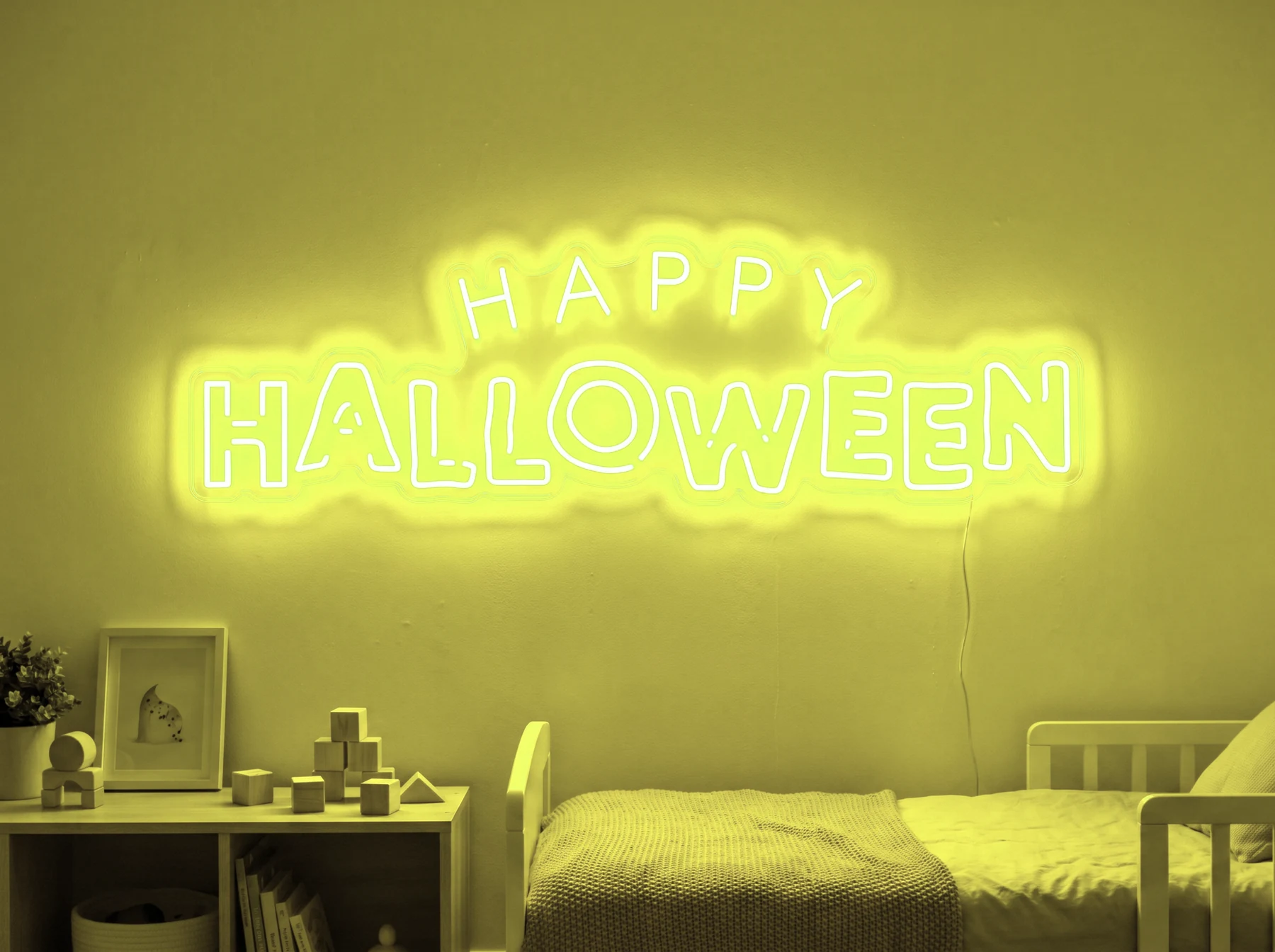 Neonskylt «Happy Halloween» i gul LED-neon, monterad på vägg