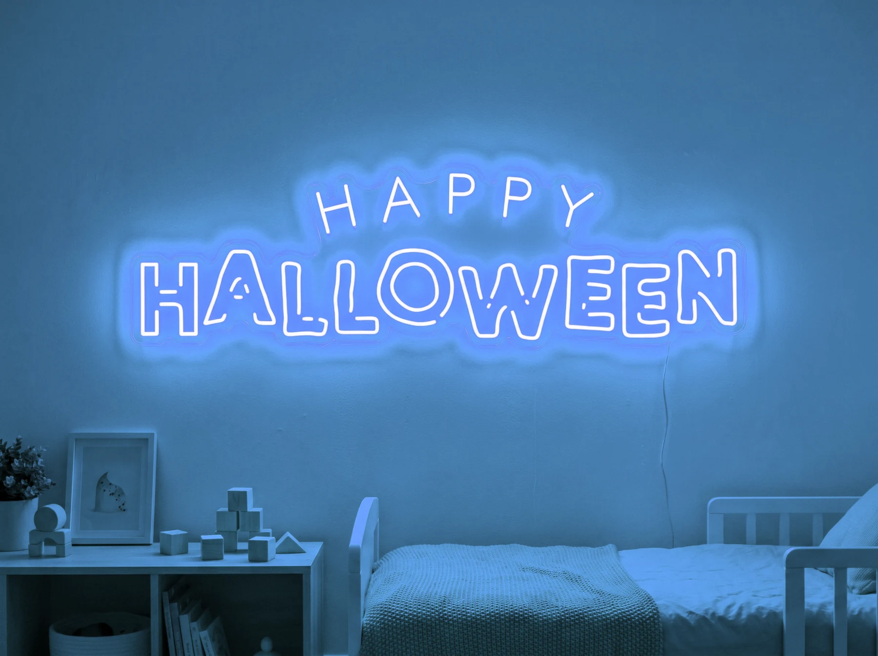 Neonskylt «Happy Halloween» i isblå LED-neon, monterad på vägg