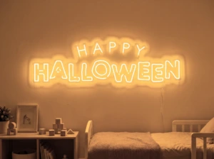 Neonskylt «Happy Halloween» i orange LED-neon, monterad på vägg
