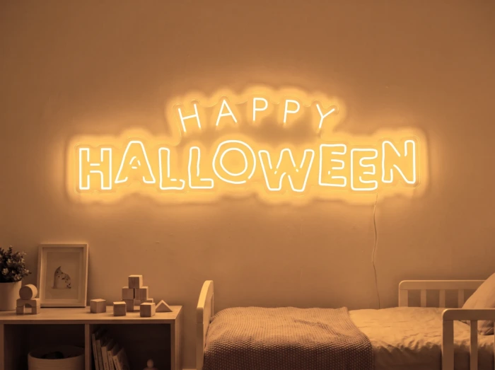 Neonskylt «Happy Halloween» i orange LED-neon, monterad på vägg