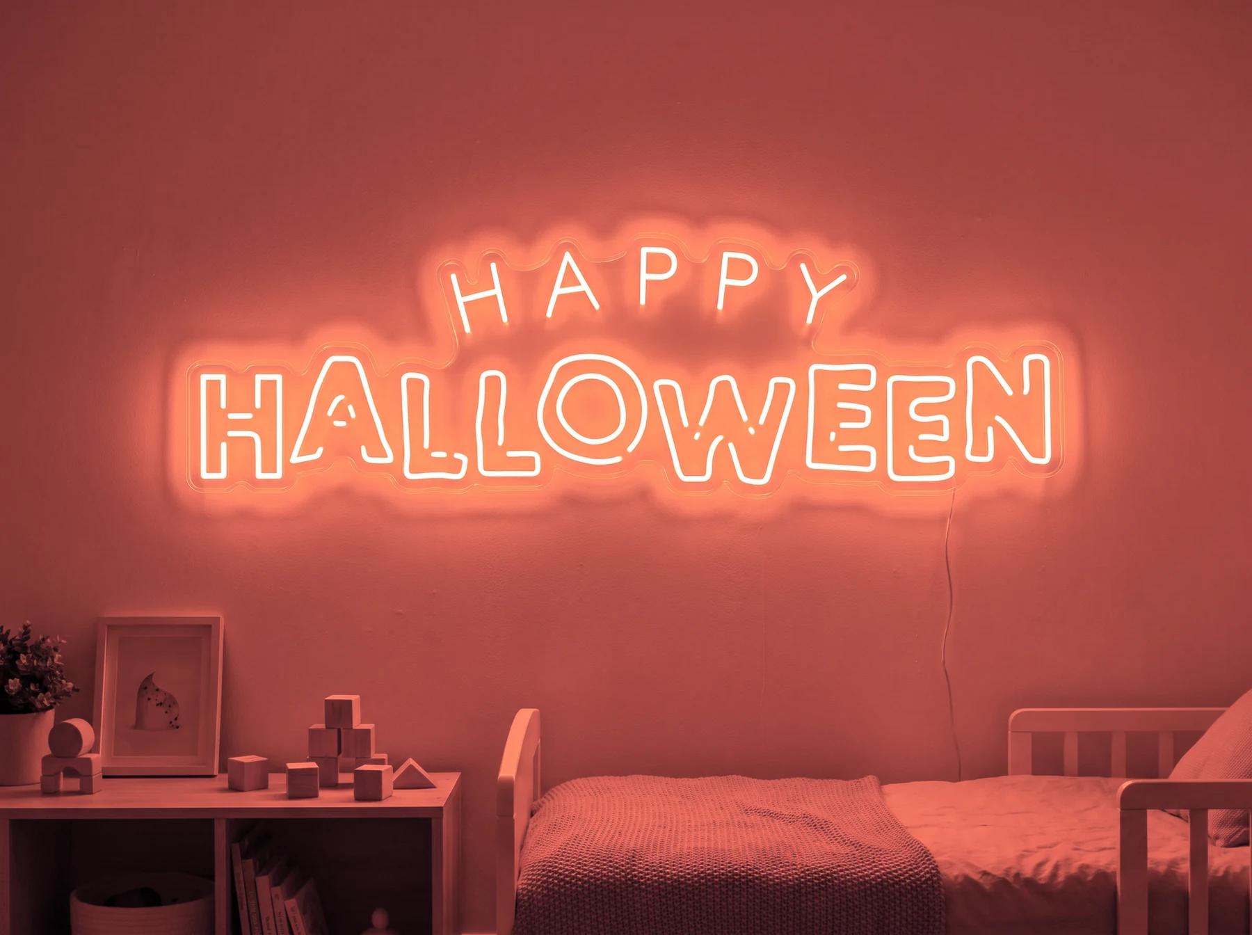 Neonskylt «Happy Halloween» i röd LED-neon, monterad på vägg