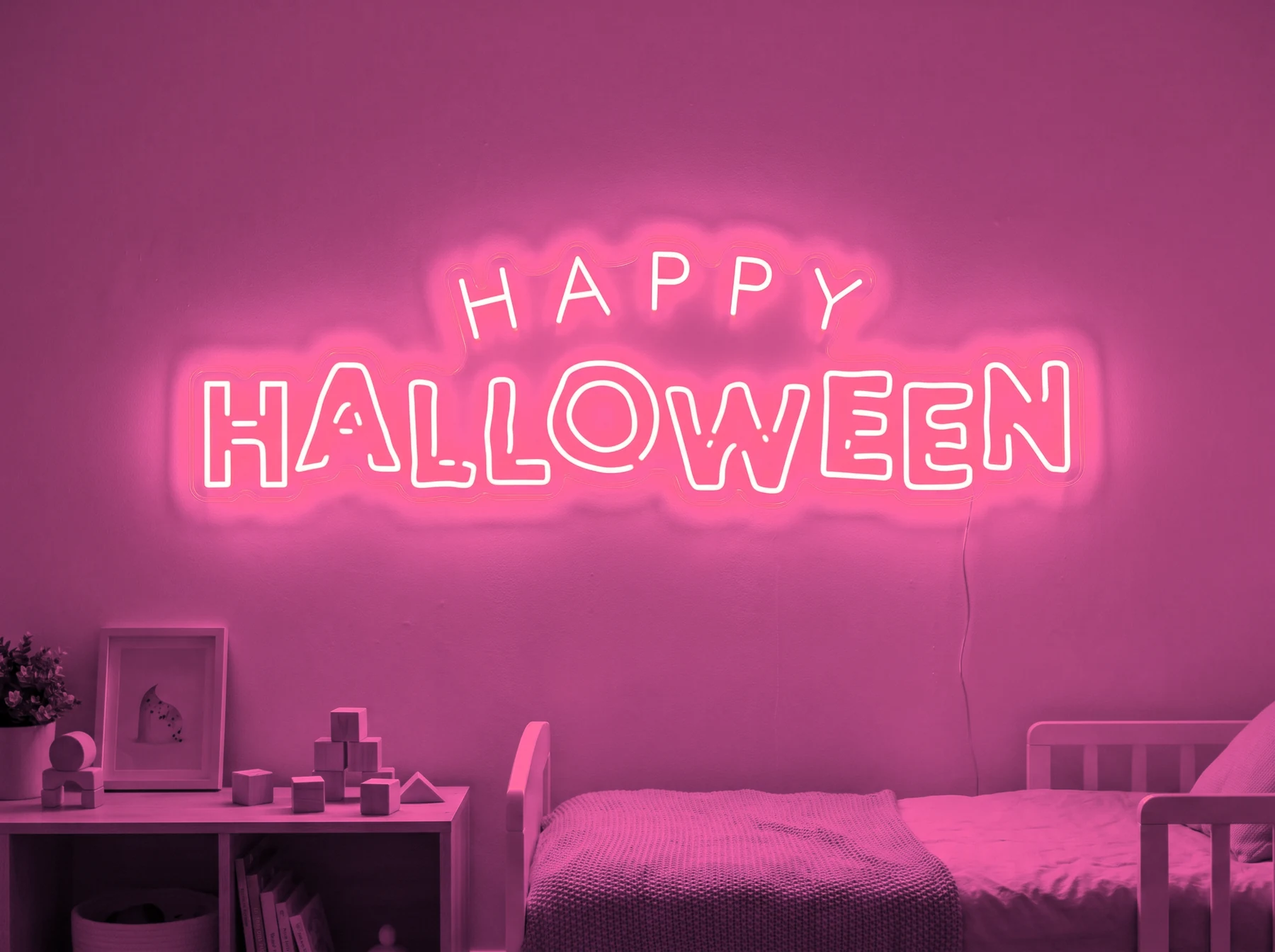 Neonskylt «Happy Halloween» i rosa LED-neon, monterad på vägg