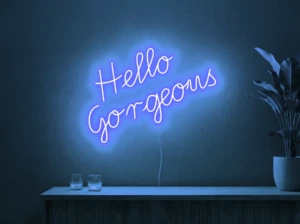 Neonskylt «Hello Gorgeous» i isblå LED-neon, monterad på vägg