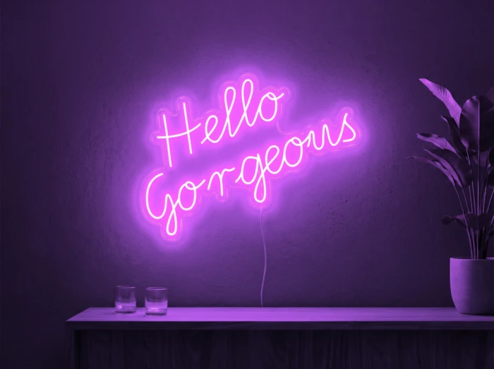 Neonskylt «Hello Gorgeous» i lila LED-neon, monterad på vägg