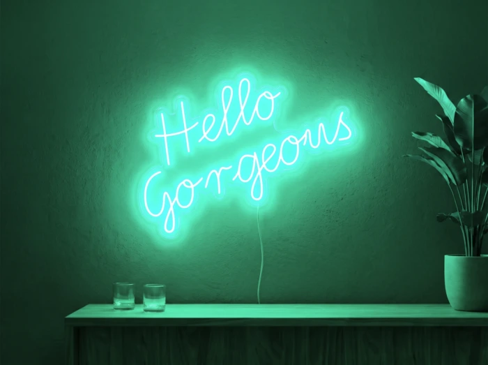 Neonskylt «Hello Gorgeous» i mintgrön LED-neon, monterad på vägg