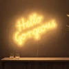 Neonskylt «Hello Gorgeous» i orange LED-neon, monterad på vägg