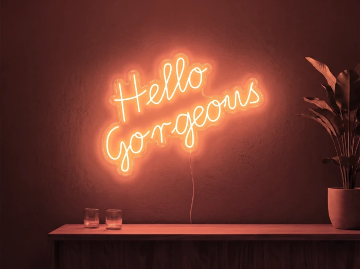Neonskylt «Hello Gorgeous» i röd LED-neon, monterad på vägg