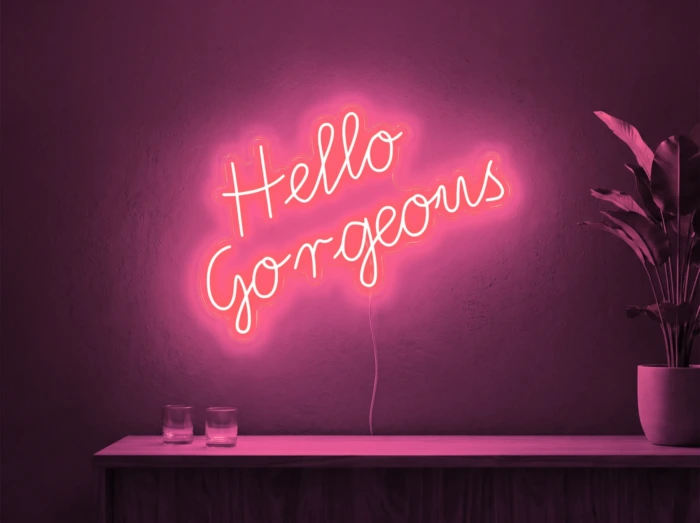 Neonskylt «Hello Gorgeous» i rosa LED-neon, monterad på vägg