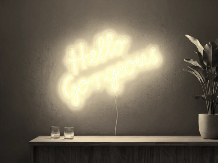 Neonskylt «Hello Gorgeous» i varmvit LED-neon, monterad på vägg