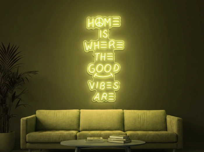 Neonskylt «Home Is Where The Good Vibes Are» i gul LED-neon, monterad på vägg