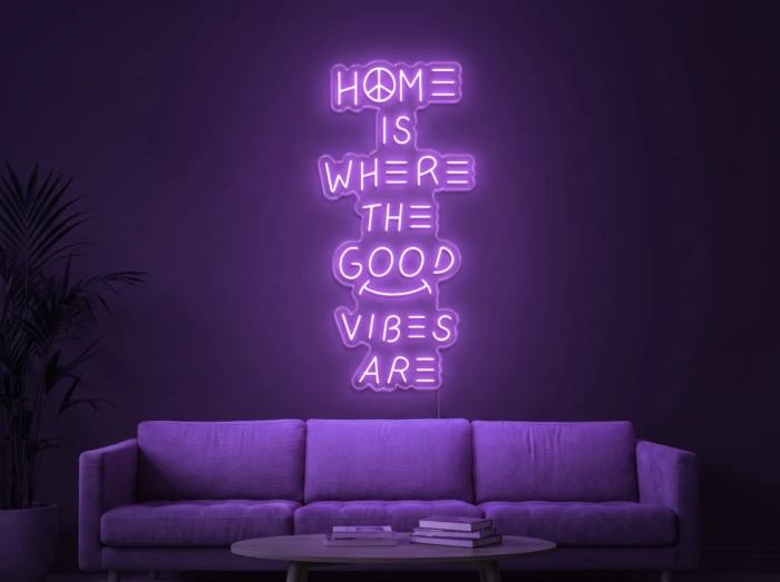 Neonskylt «Home Is Where The Good Vibes Are» i lila LED-neon, monterad på vägg