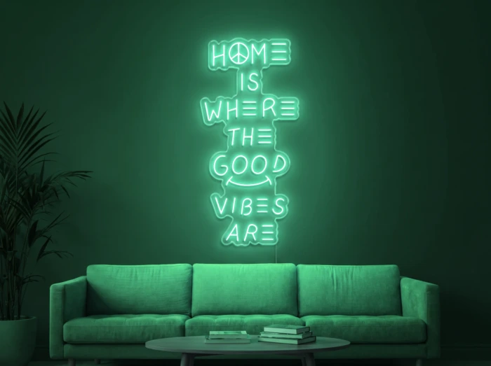 Neonskylt «Home Is Where The Good Vibes Are» i mintgrön LED-neon, monterad på vägg