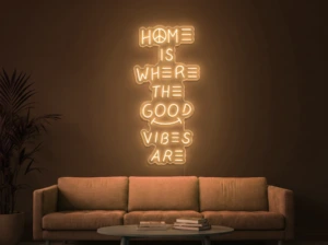 Neonskylt «Home Is Where The Good Vibes Are» i orange LED-neon, monterad på vägg