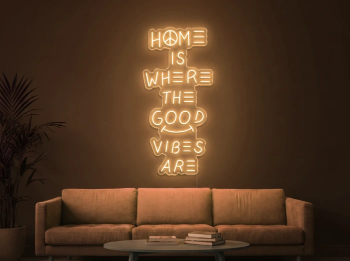 Neonskylt «Home Is Where The Good Vibes Are» i orange LED-neon, monterad på vägg