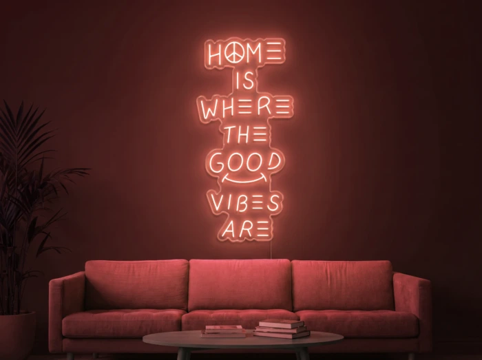 Neonskylt «Home Is Where The Good Vibes Are» i röd LED-neon, monterad på vägg