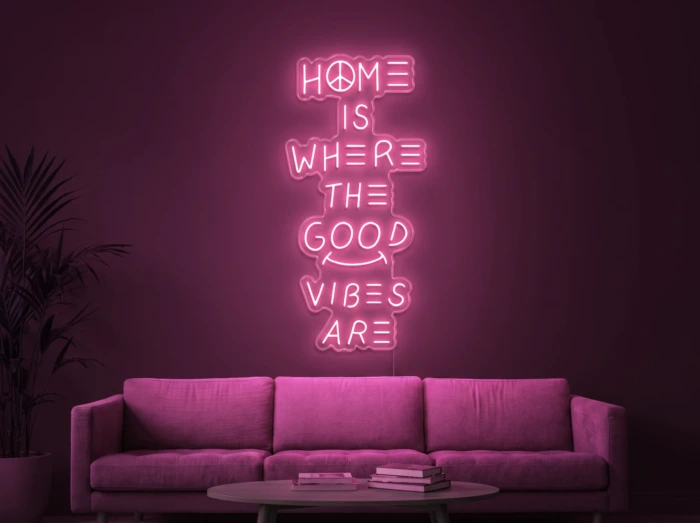 Neonskylt «Home Is Where The Good Vibes Are» i rosa LED-neon, monterad på vägg
