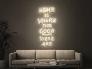 Neonskylt «Home Is Where The Good Vibes Are» i varmvit LED-neon, monterad på vägg