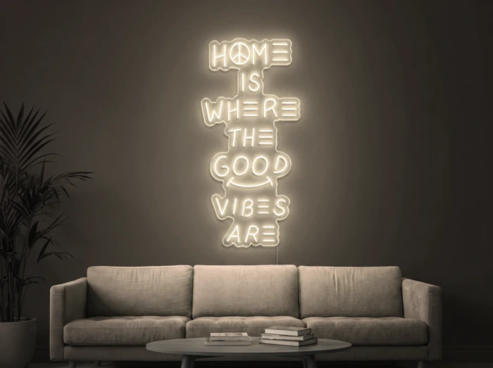 Neonskylt «Home Is Where The Good Vibes Are» i varmvit LED-neon, monterad på vägg