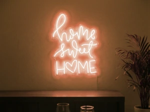 Neonskylt «Home Sweet Home» i orange LED-neon, monterad på vägg