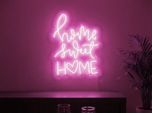 Neonskylt «Home Sweet Home» i rosa LED-neon, monterad på vägg