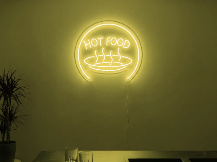 Neonskylt «Hot Food» i gul LED-neon, monterad på vägg