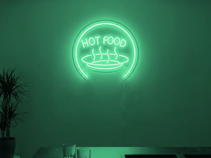 Neonskylt «Hot Food» i mintgrön LED-neon, monterad på vägg