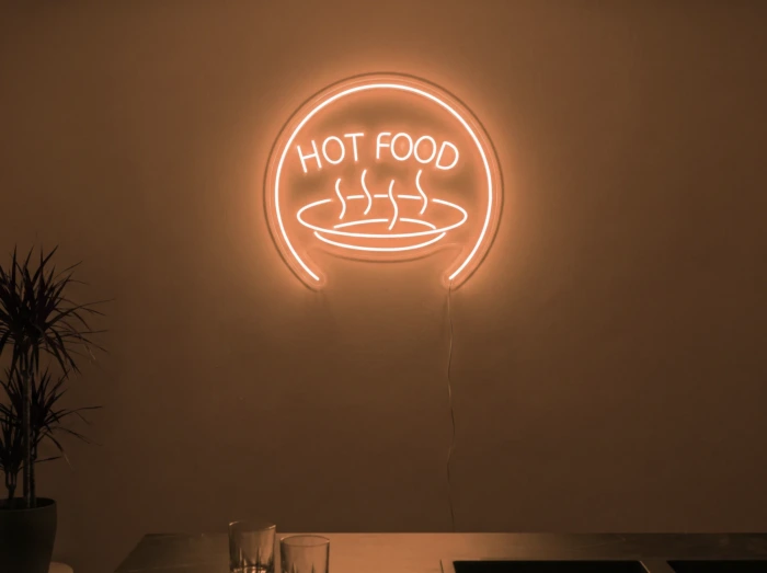 Neonskylt «Hot Food» i orange LED-neon, monterad på vägg